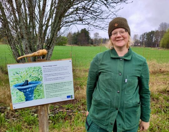Elin Boström visar en av skyltarna på slingan om biologisk mångfald på Bobrunna gård.